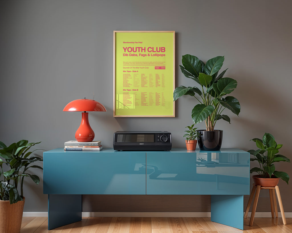 80s Youth Club music print hanging in a black frame against a light grey wall above a blue sideboard with gentle window reflections on the glass. Suitable for A1, A2 and A3 sizes. Acid yellow background with electric pink text (Mockup M06).