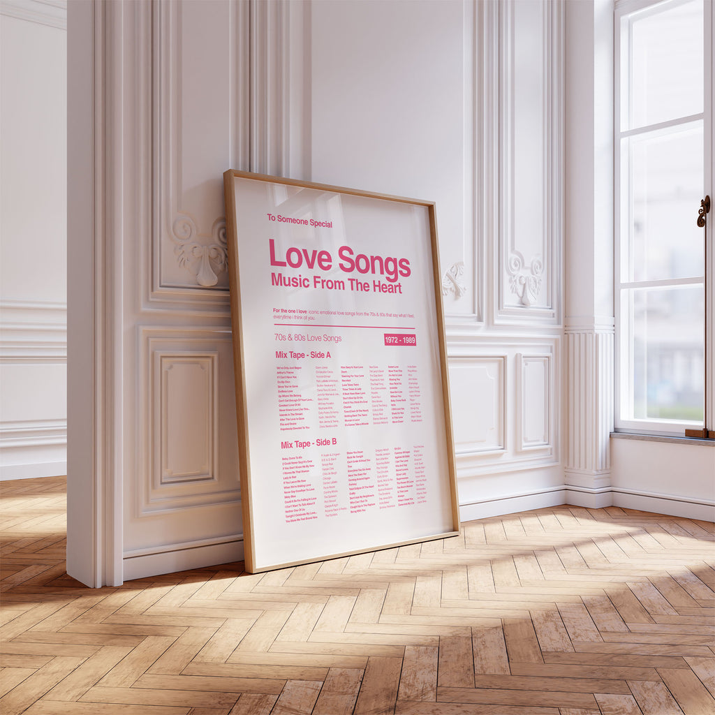 Framed poster titled 'Love Songs Music From The Heart' on a wooden floor with white walls.
