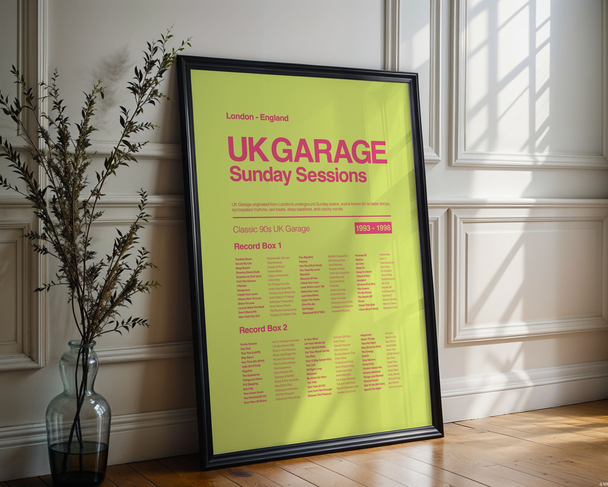 UK Garage music print in a black frame resting on an ornate white wall with subtle reflections and gentle wall shadows. Suitable for A1, A2 and A3 sizes. Acid yellow background with electric pink text (Mockup M07).